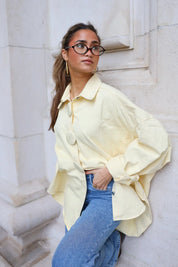 denim blouse geel dames staand bij muur