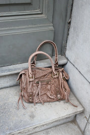 Denim city bag bruin geplaatst op trap