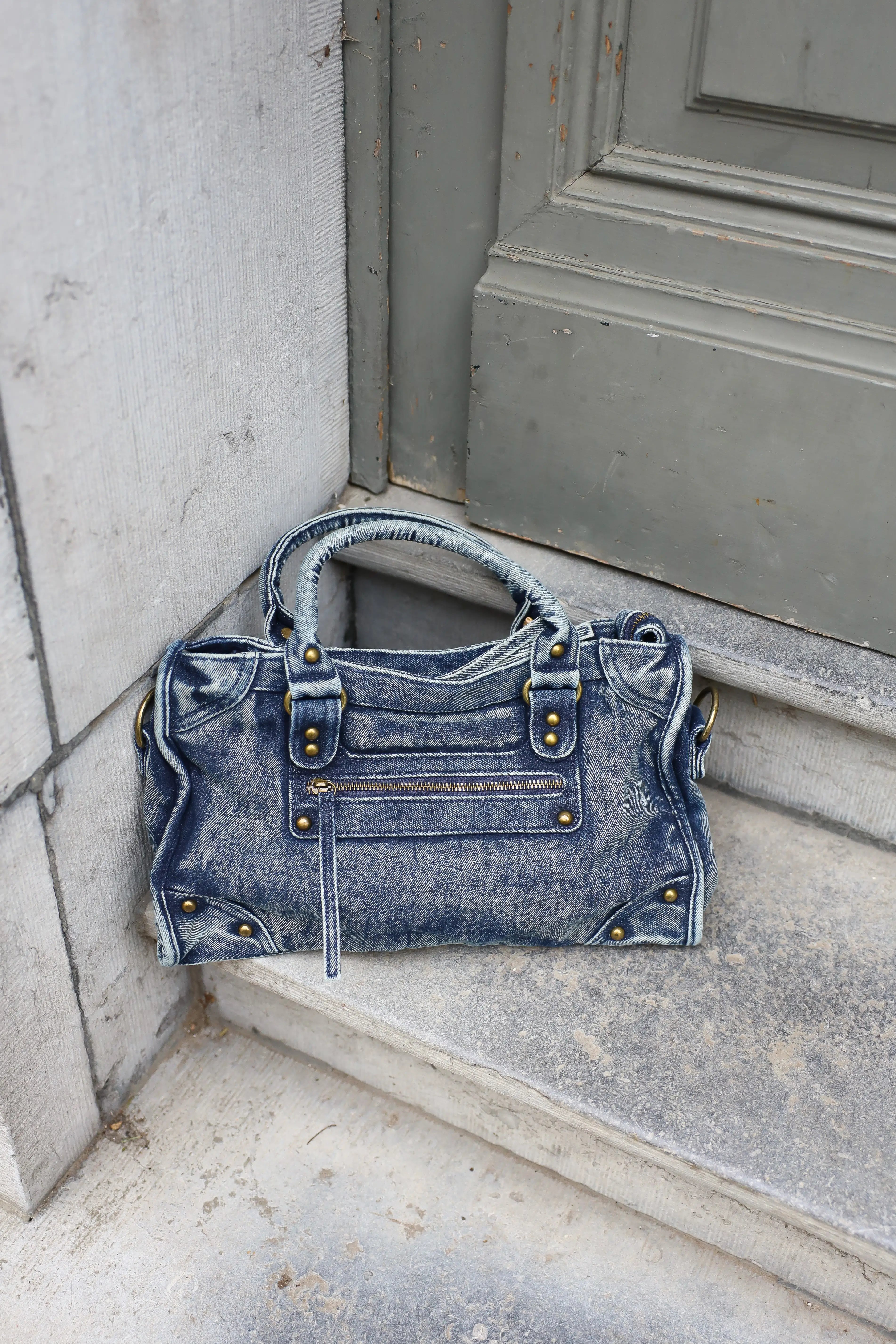 Denim schoudertas jeans blauw geplaatst op trap