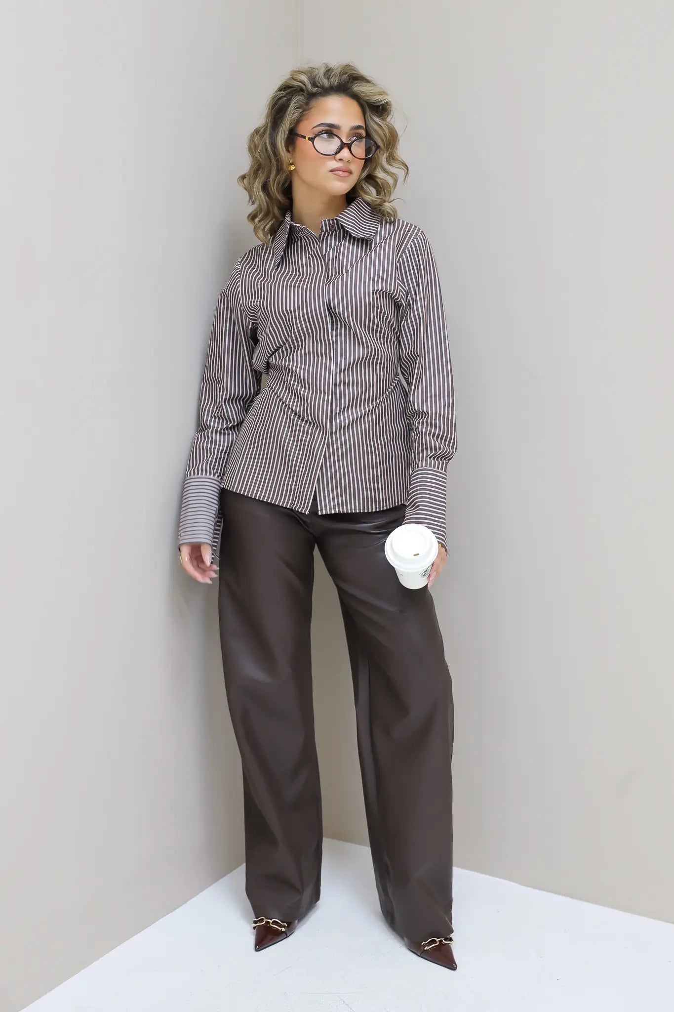 Model met faux leather broek en blouse met print, recht voor camera