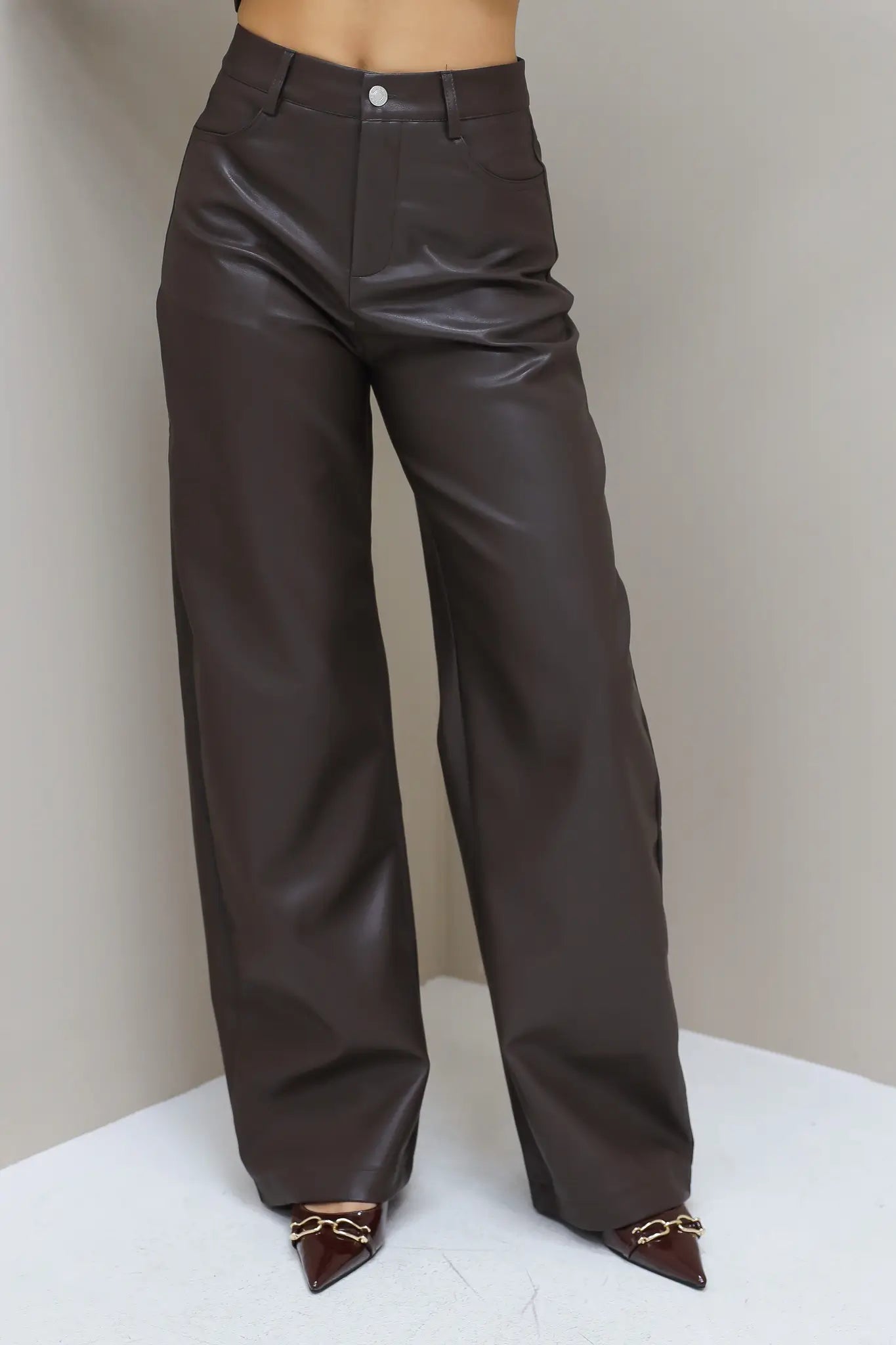 Broek van voren getoond op witte achtergrond, zicht op tailleband en rechte pijpen