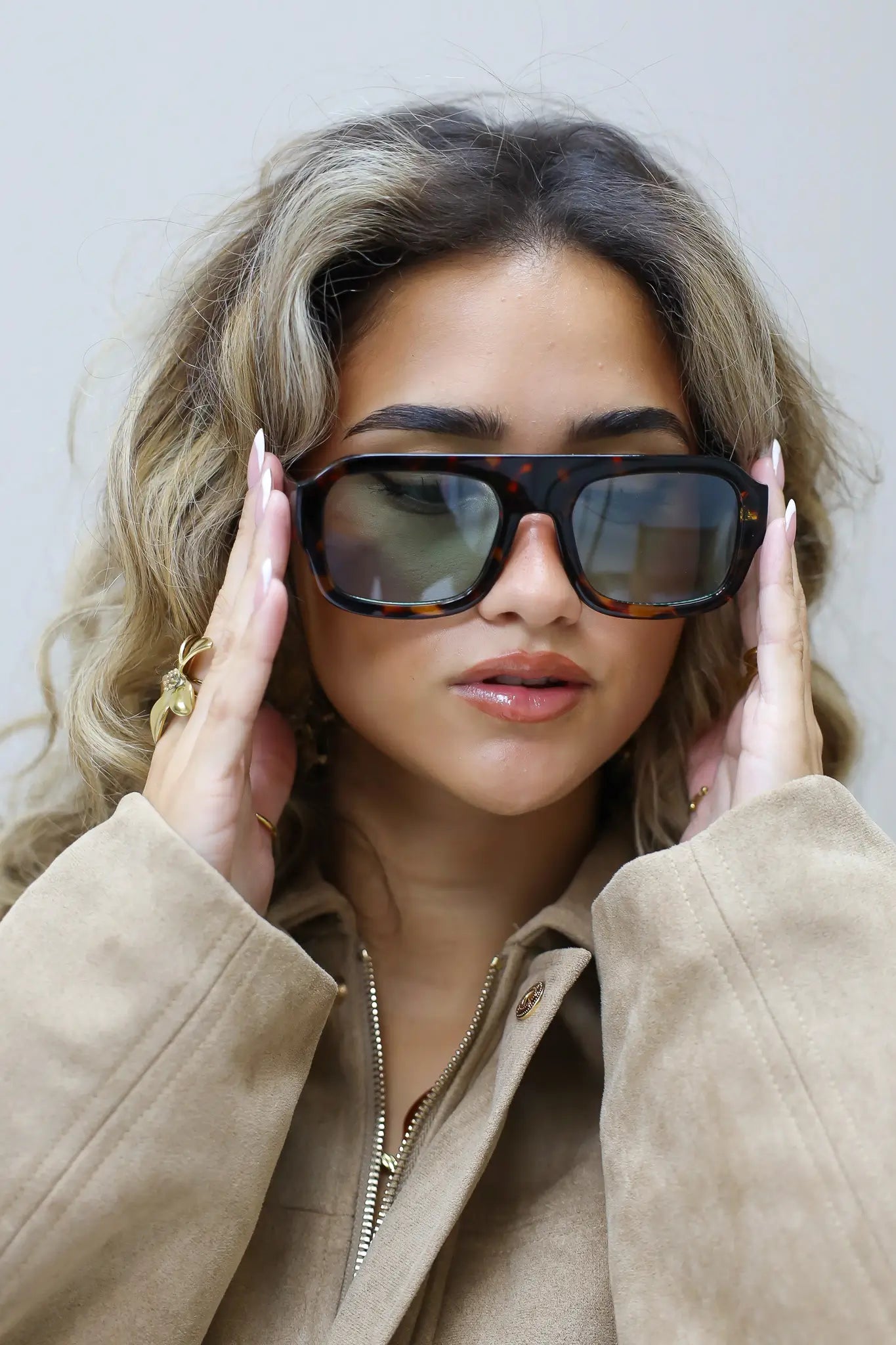 model kijkt recht in de camera met los haar en neutrale blik