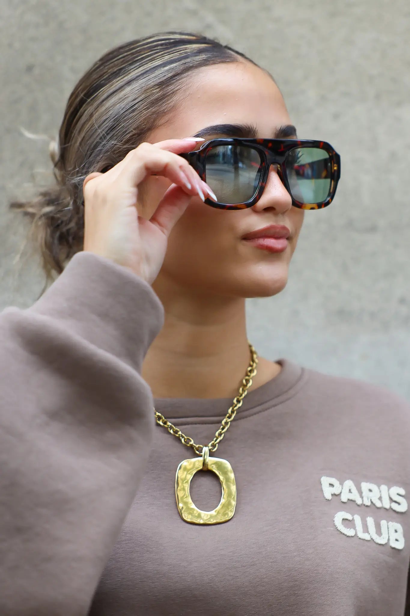 model tilt zonnebril iets op en kijkt richting camera