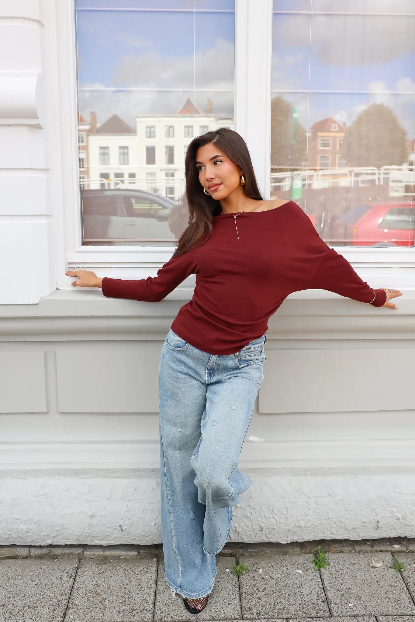 Donkerrode longsleeve dames gecombineerd met jeans
