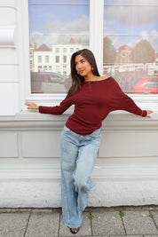 Donkerrode longsleeve dames gecombineerd met jeans