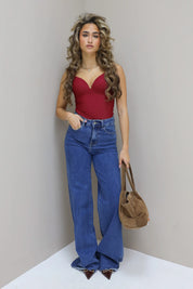 Model recht voor camera, hand in zak, bruine tas zichtbaar