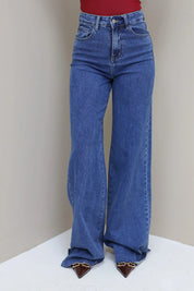 Jeans over de hele lengte zichtbaar, model in rode top met bruine tas