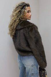 model draait licht weg met faux fur jasje in studio