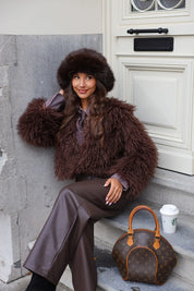 Close-up van model met bruine fluffy muts en bruine jas