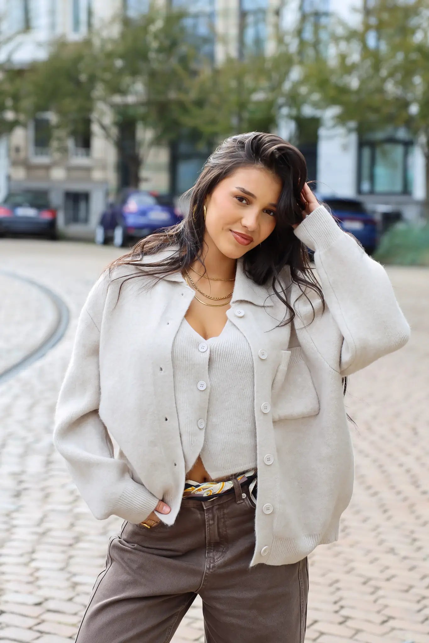 gebreide vest beige dames vest knopen kort model zittende streetstyle foto close up dichtbij