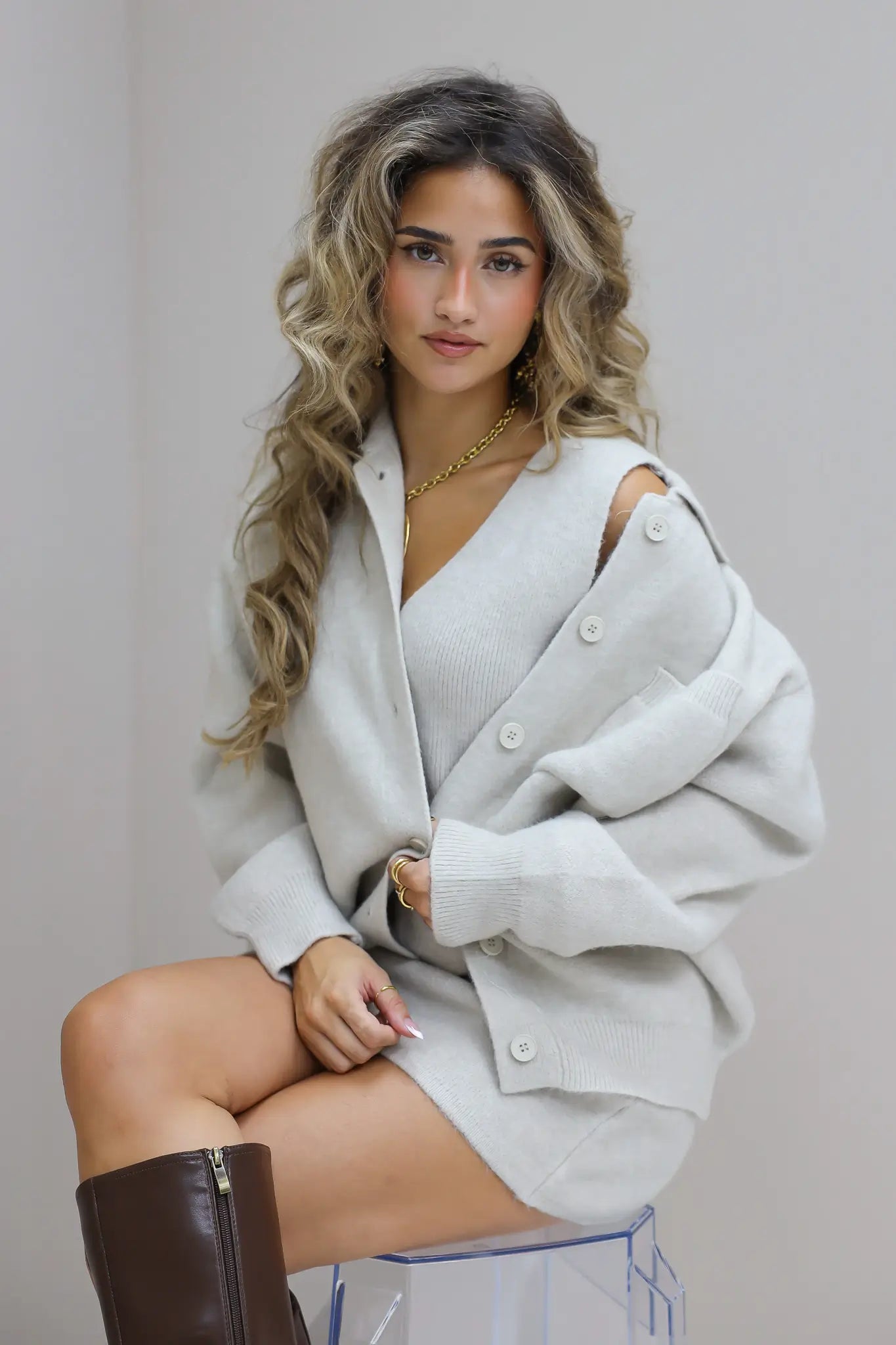 gebreide vest beige dames vest knopen kort model zittende studio foto close up zijkant dichtbij