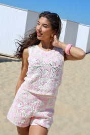 model met beige roze gehaakt setje staand op het strand