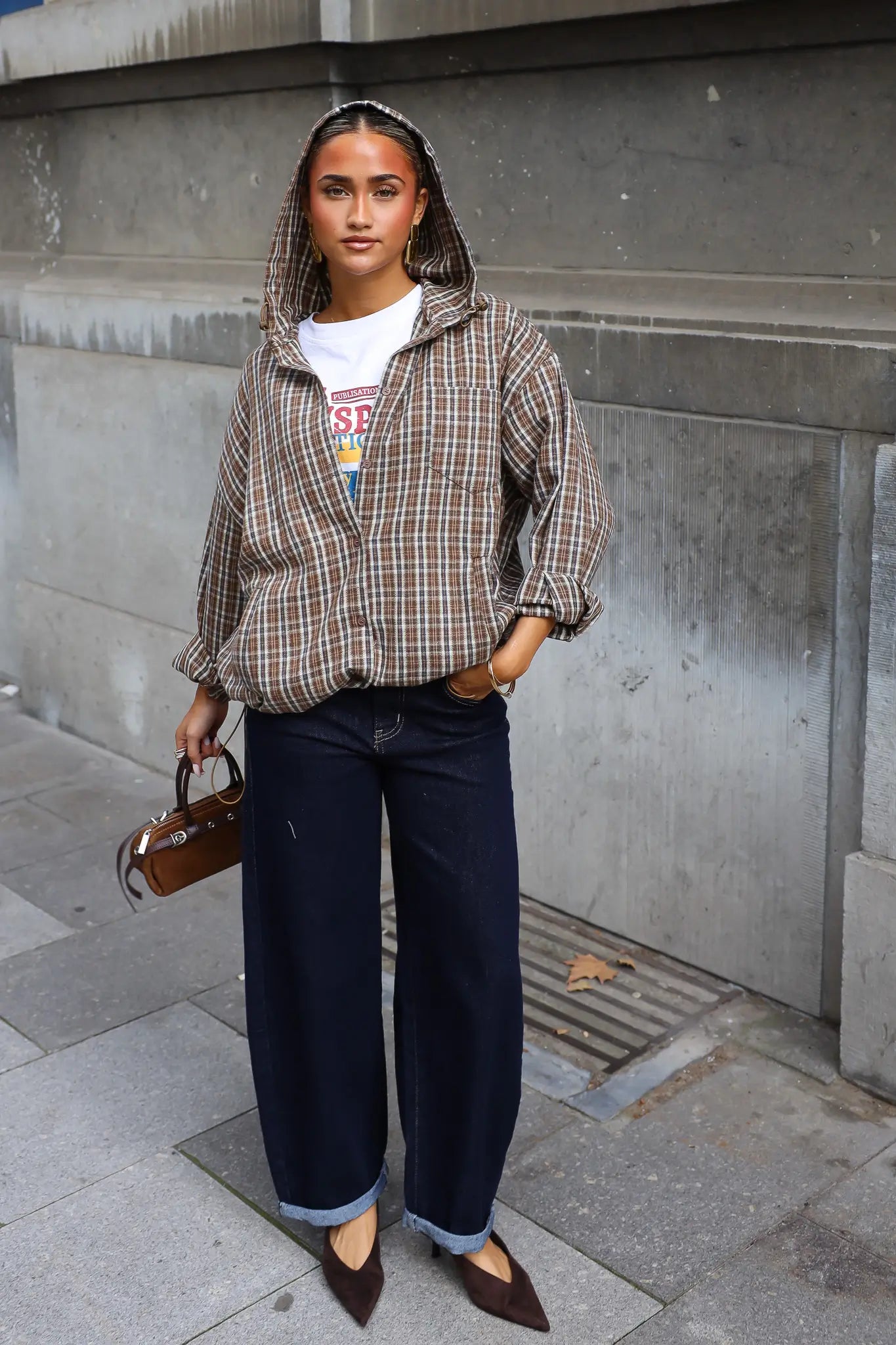 Geruite blouse met capuchon in camel en bruin gecombineerd met donkere wide leg jeans en bruine handtas
