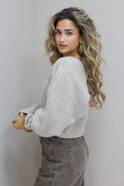 Studiofoto zijaanzicht van model met grijs vest