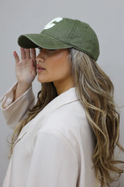 model draagt groene pet dames zijaanzicht met blazer outfit