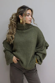 Model draagt een groene coltrui in studio