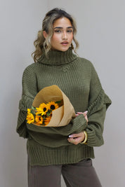 Model poseert met zonnebloemen in groene trui