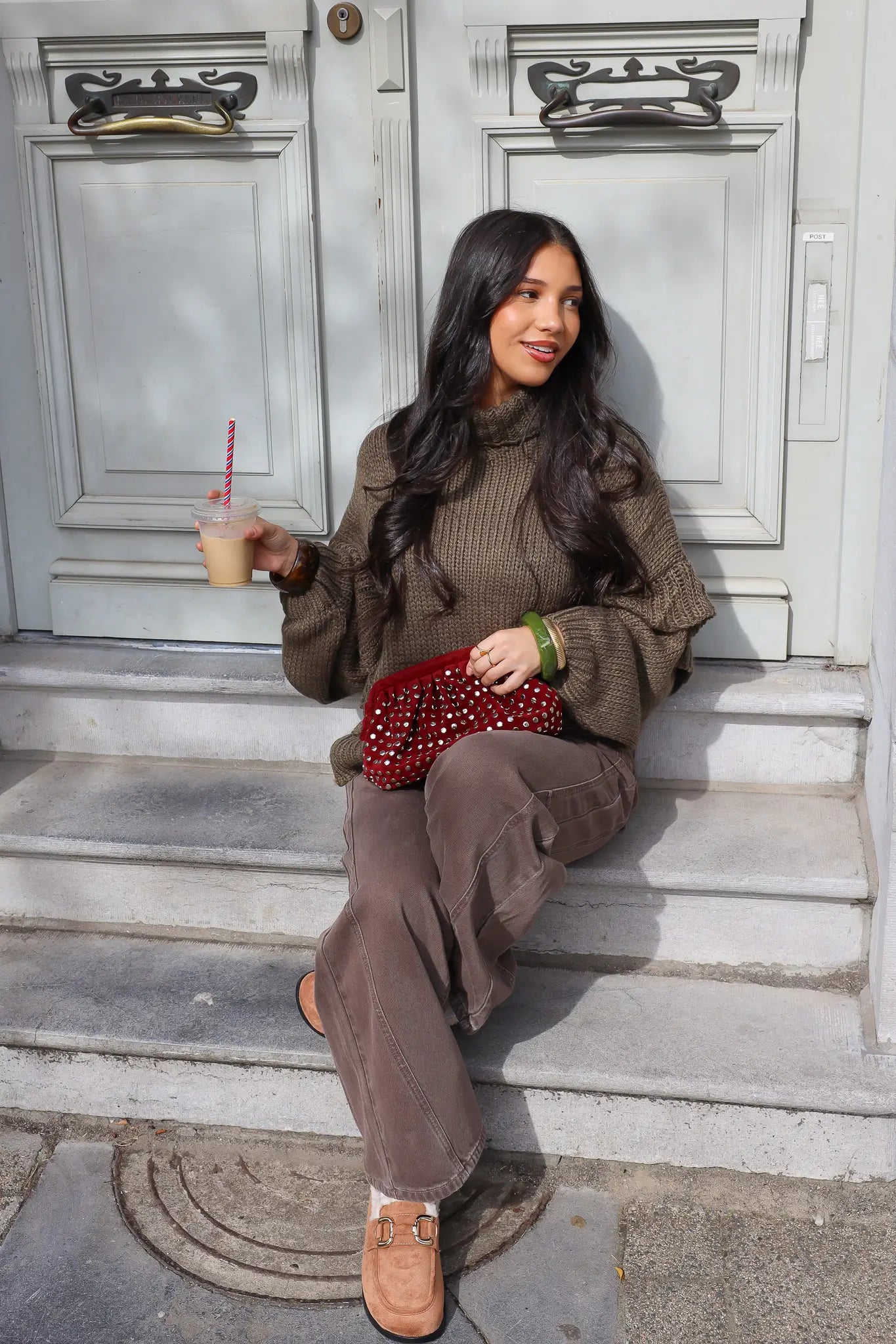 Model zit op een trap met groene trui