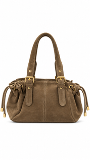 Productfoto van een taupe handtas met suèdelook, dubbele hengsels, goudkleurige details en gespen op een witte achtergrond.