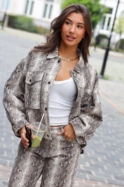 Jas Zakken Slangenprint Beige dames gecombineerd met witte top en matching jeans