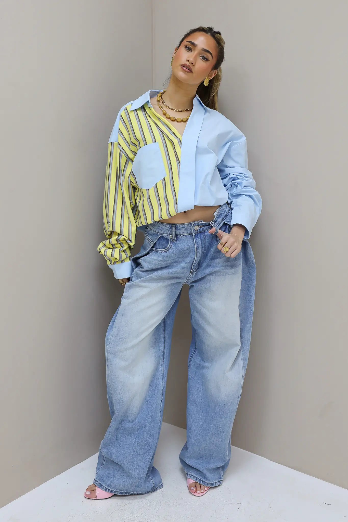 Model draagt jeans plooi effect blauw met wijde pijpen en lichte wassing