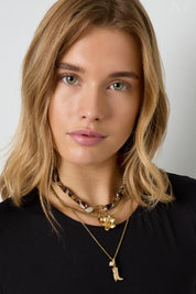 Model draagt de Ketting Bloem Luipaard Bruin met luipaardprint en gouden bloemdetails