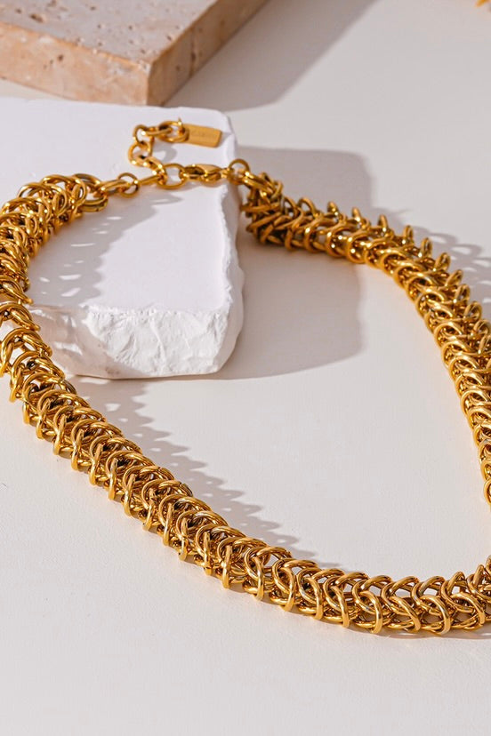 Detail van de gehaakte schakels van de goudkleurige ketting