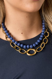 close-up van vrouw met grove gouden cirkelketting om haar hals