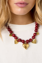 Close-up van Ketting Kralen Hartjes Bordeaux met gouden hartjes en rode kralen