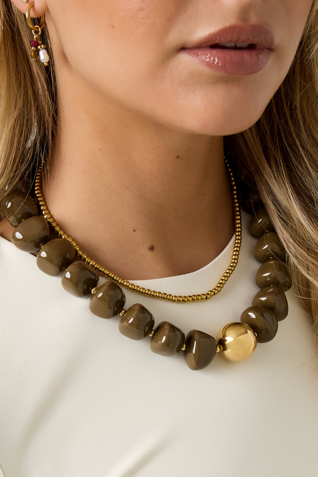 Ketting met bruine acryl kralen gedragen door model