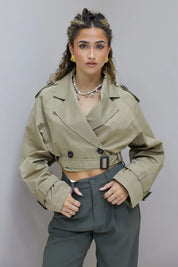 model met beige trenchcoat en gouden halsketting met parels en charms