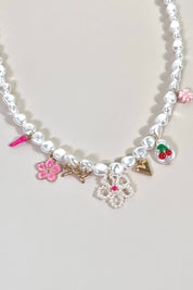 halsketting met parels en kleurrijke bedels op lichte ondergrond