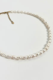 gouden halsketting met parels vanuit zijaanzicht op witte ondergrond