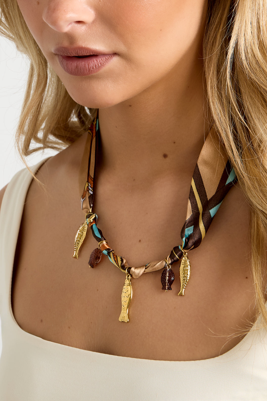 Lange ketting met stoffen band en visjes gedragen