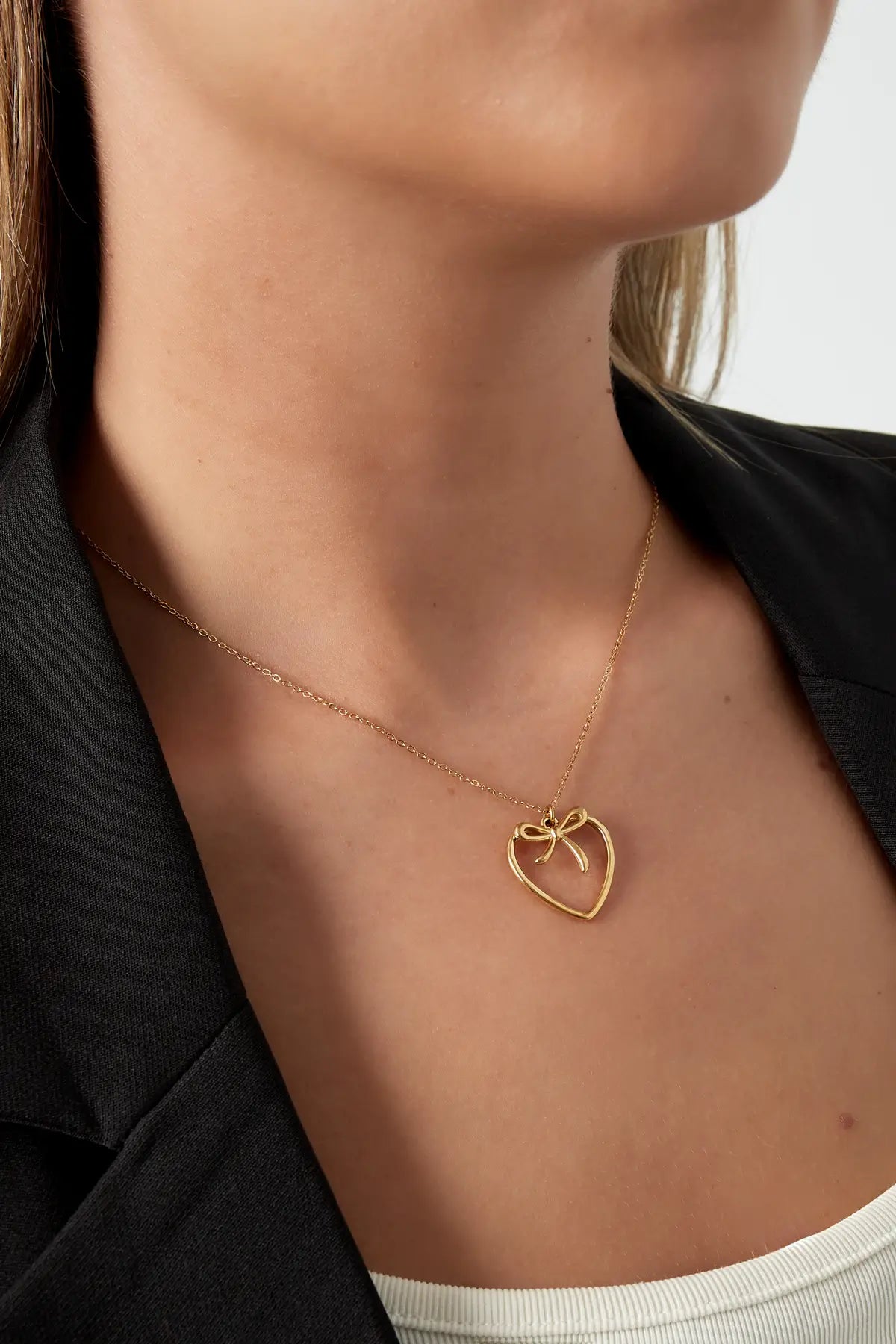 ketting strik heart goud gedragen om de hals close up