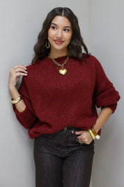 Model staat recht in de Liva trui bordeaux met zwarte broek en gouden ketting