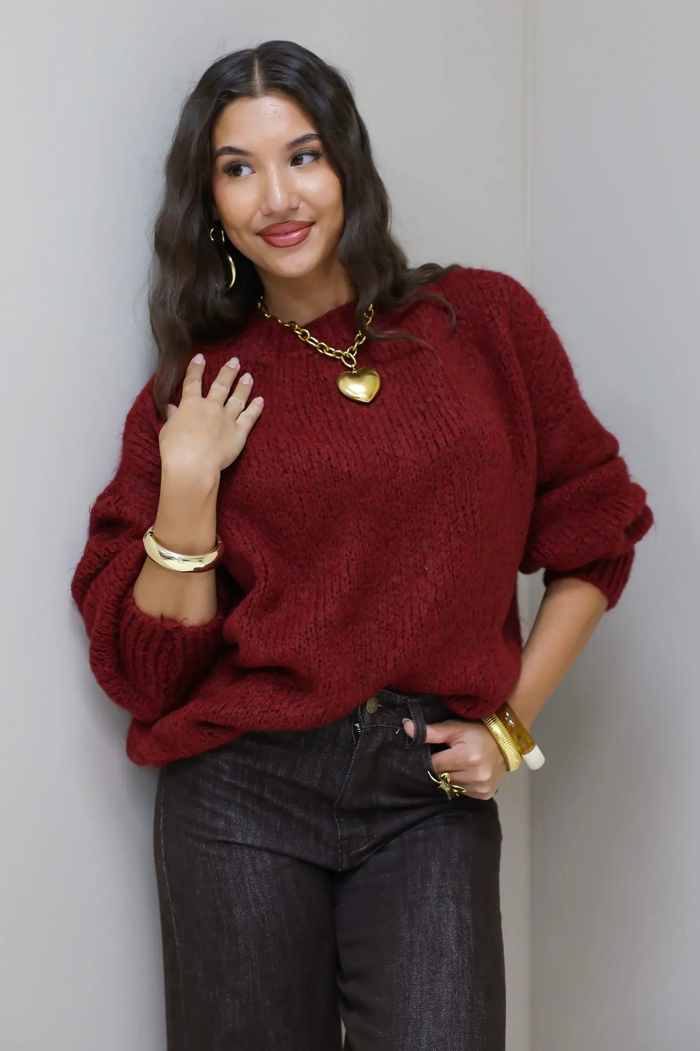 Model draagt de Liva trui bordeaux met gouden ketting en armbanden