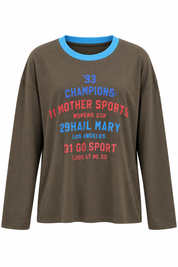 Bruine Champions longsleeve met blauwe halsboord en rode blauwe opdruk op witte achtergrond
