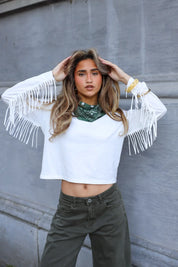 model draagt wit shirt met franjes mouwen gecombineerd met groene broek ladylike