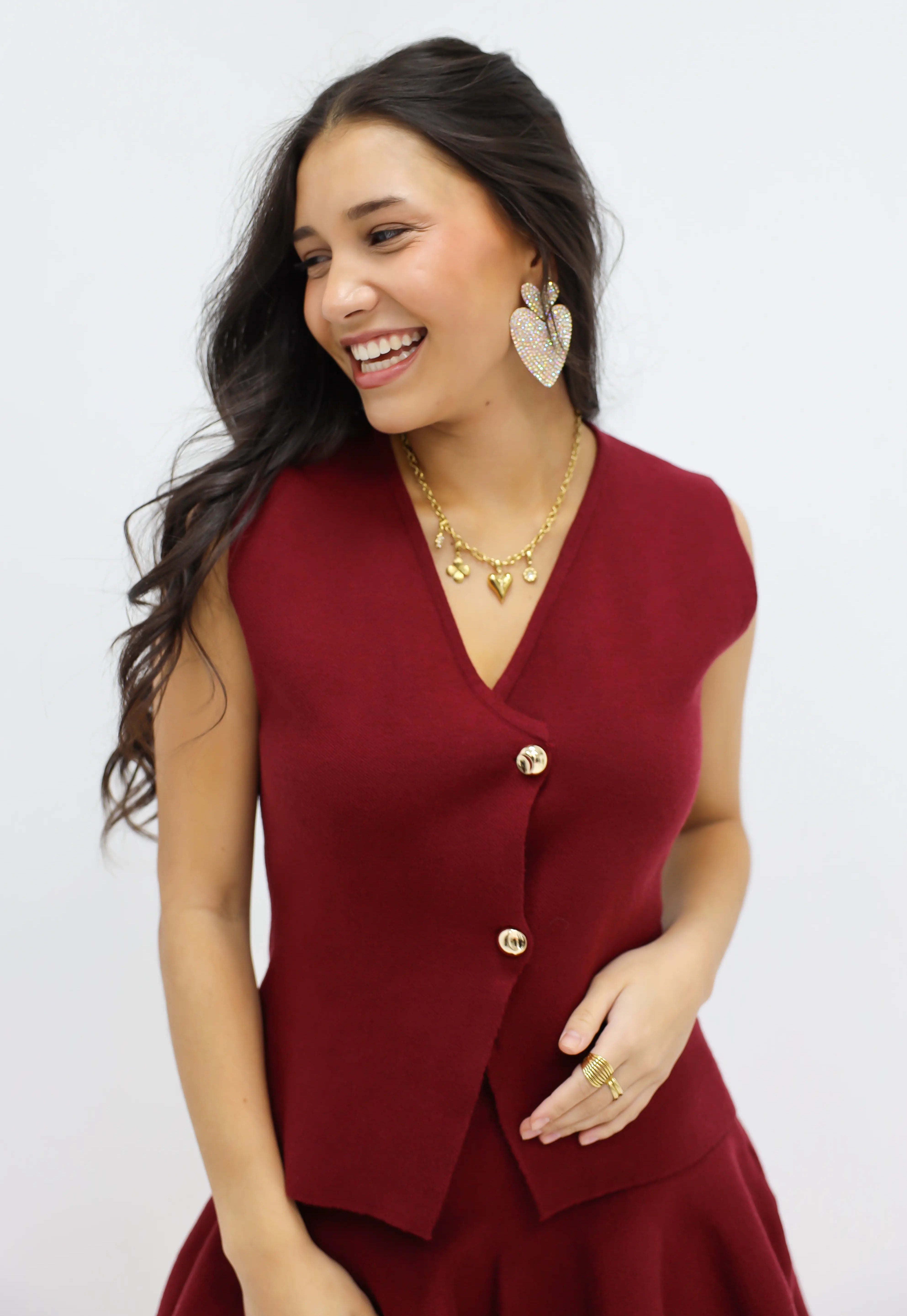 mouwloze blazer top rood model lacht handen in zakken