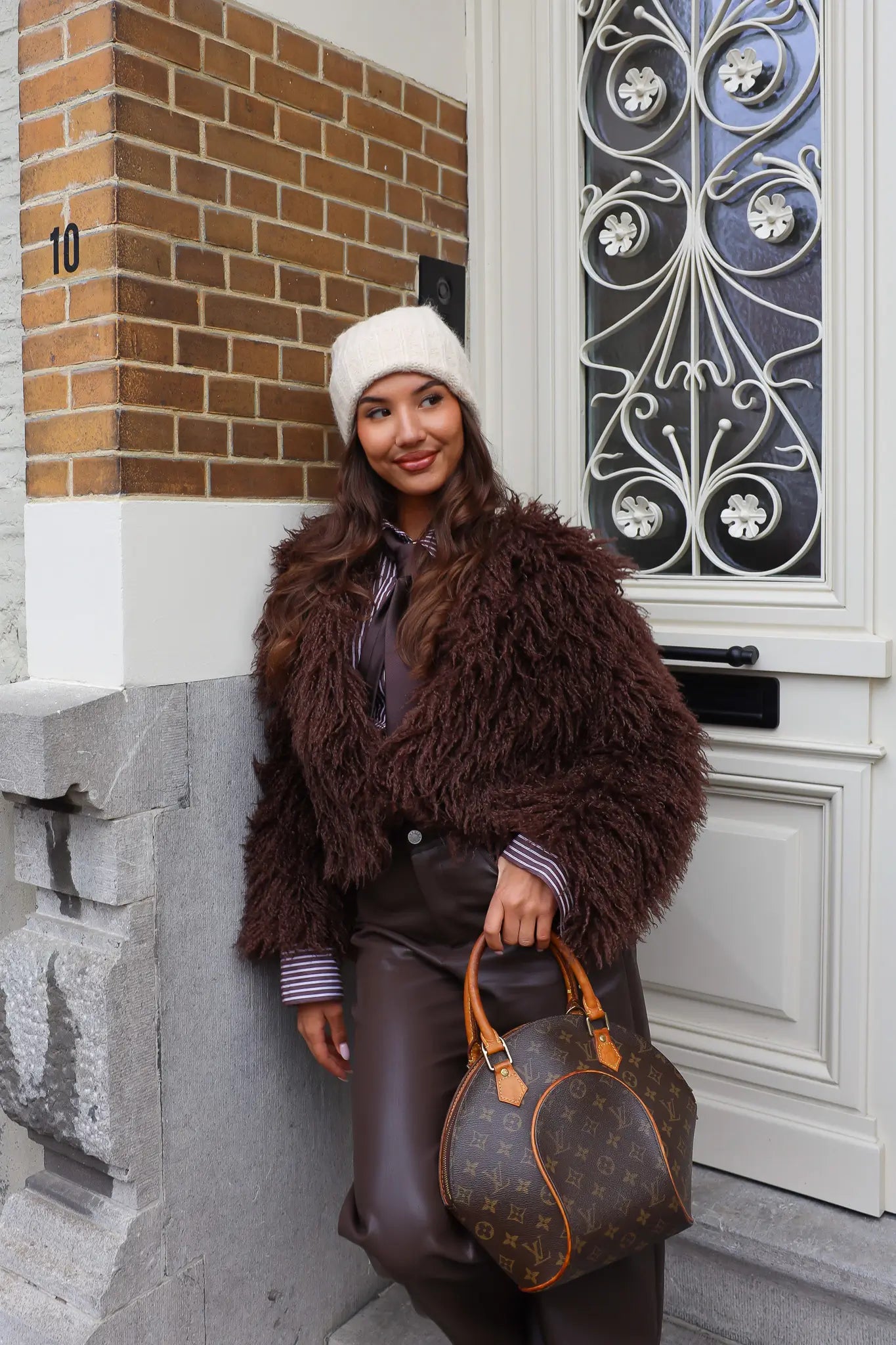 Beige gebreide muts met brede rand op witte achtergrond