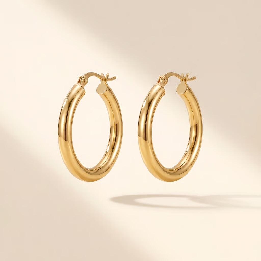 gouden dikke hoops oorbellen close up op lichte achtergrond