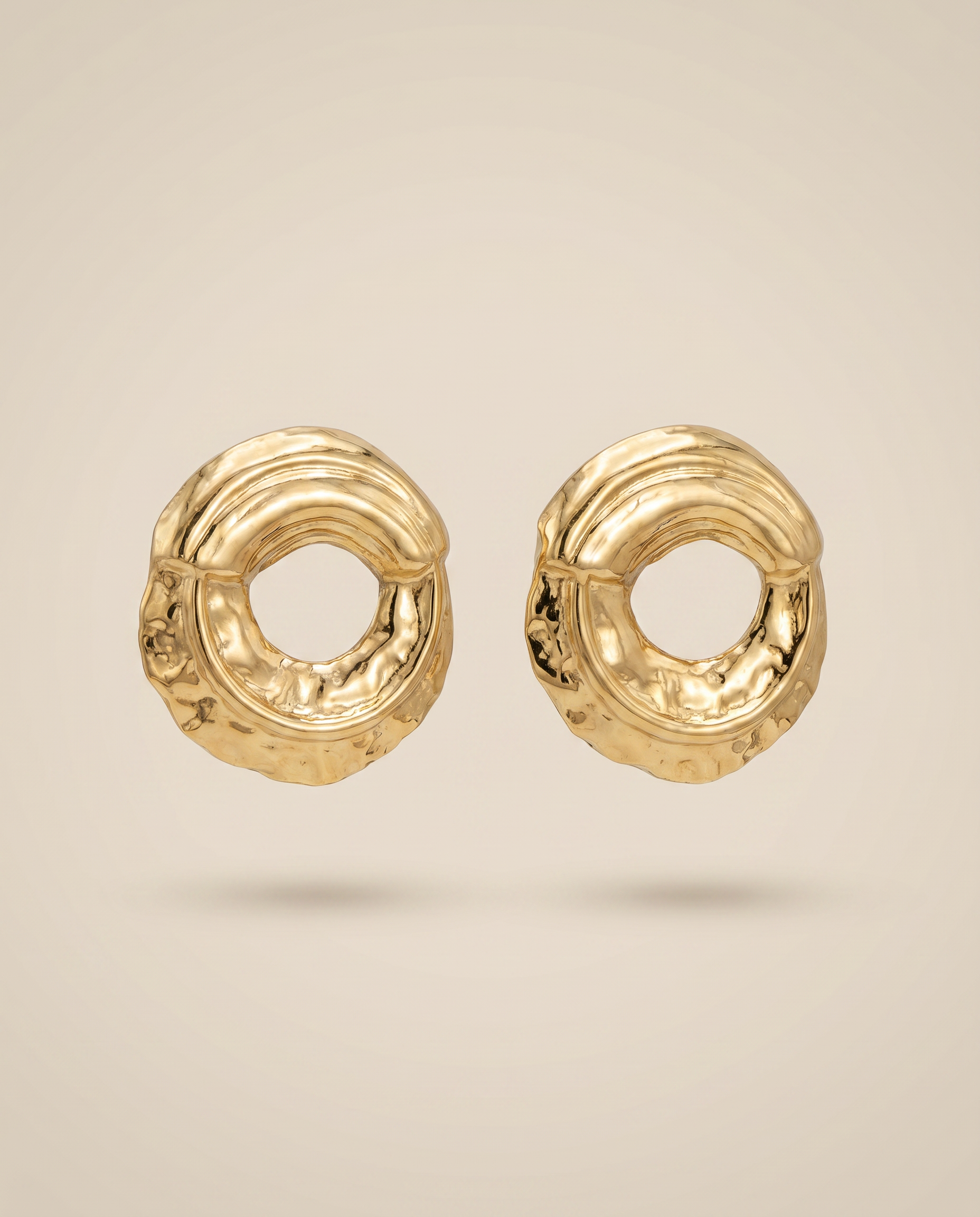 gouden sculpturale oorbellen met ronde vorm close up