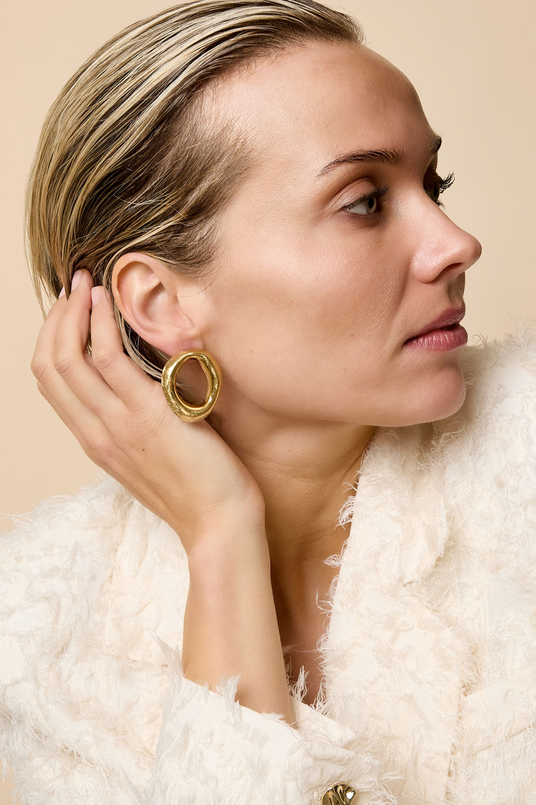 Oorbellen cirkel brushed goud gedragen aan het oor in zijaanzicht