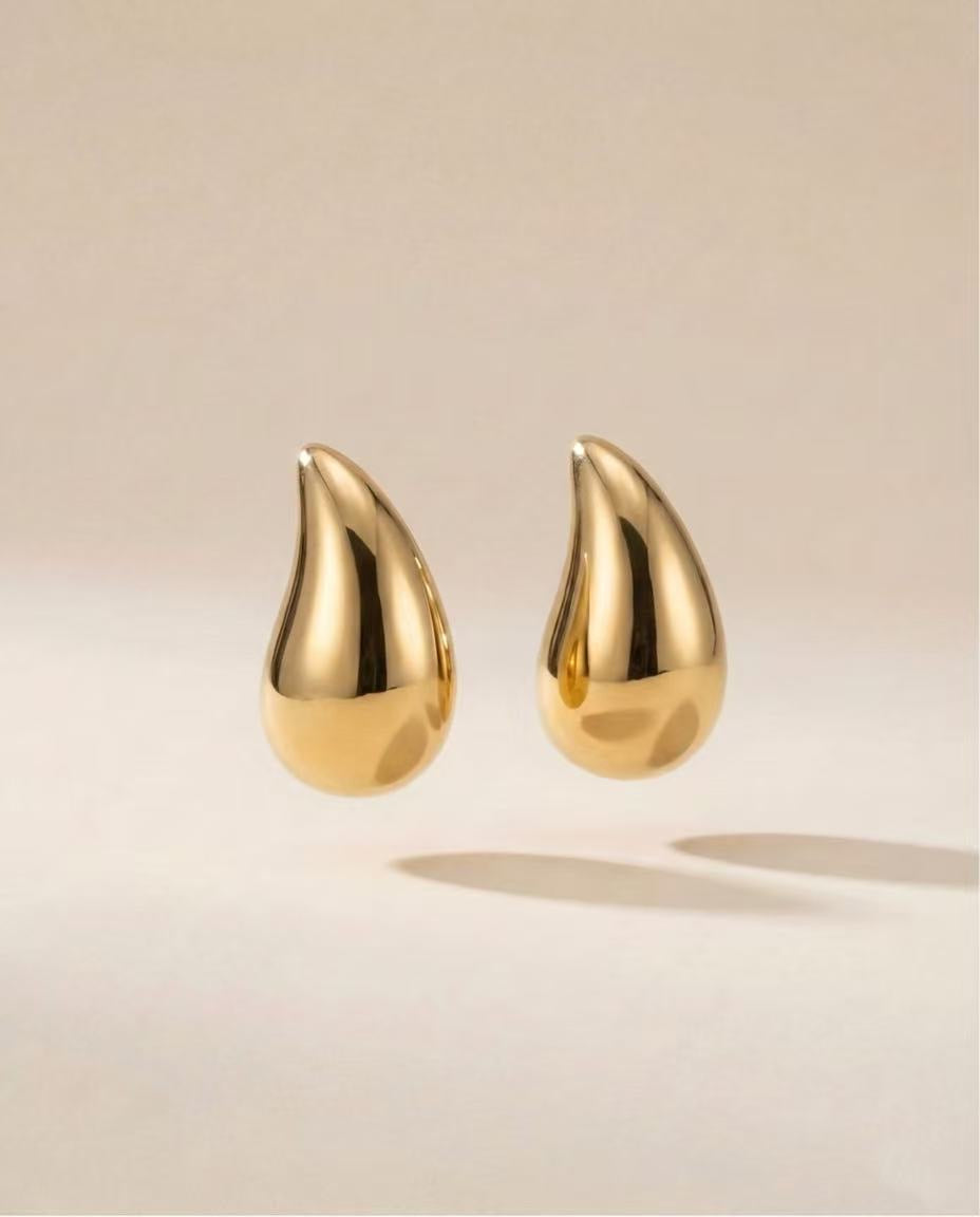 gouden oorbellen met afgeronde druppelvorm close up