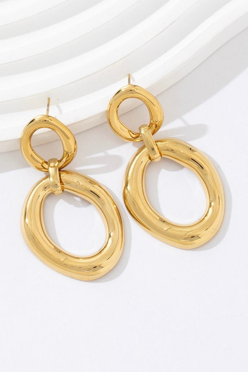 Goudkleurige oorbellen met dubbele ring op lichte achtergrond