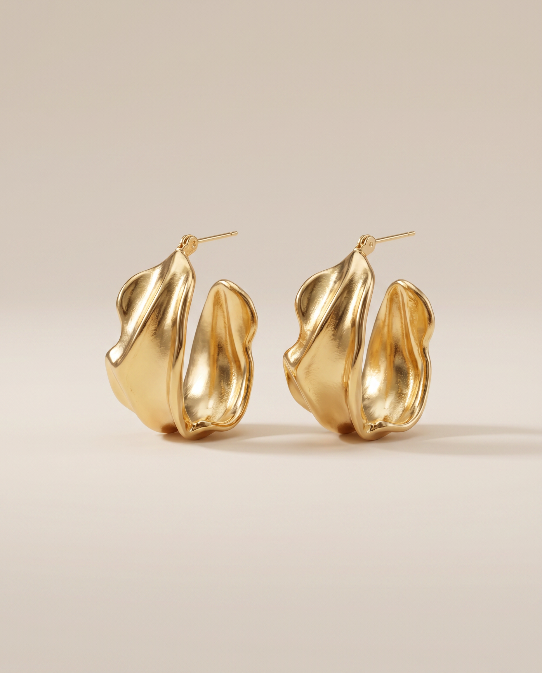 gouden oorbellen met organische bloemvorm close up