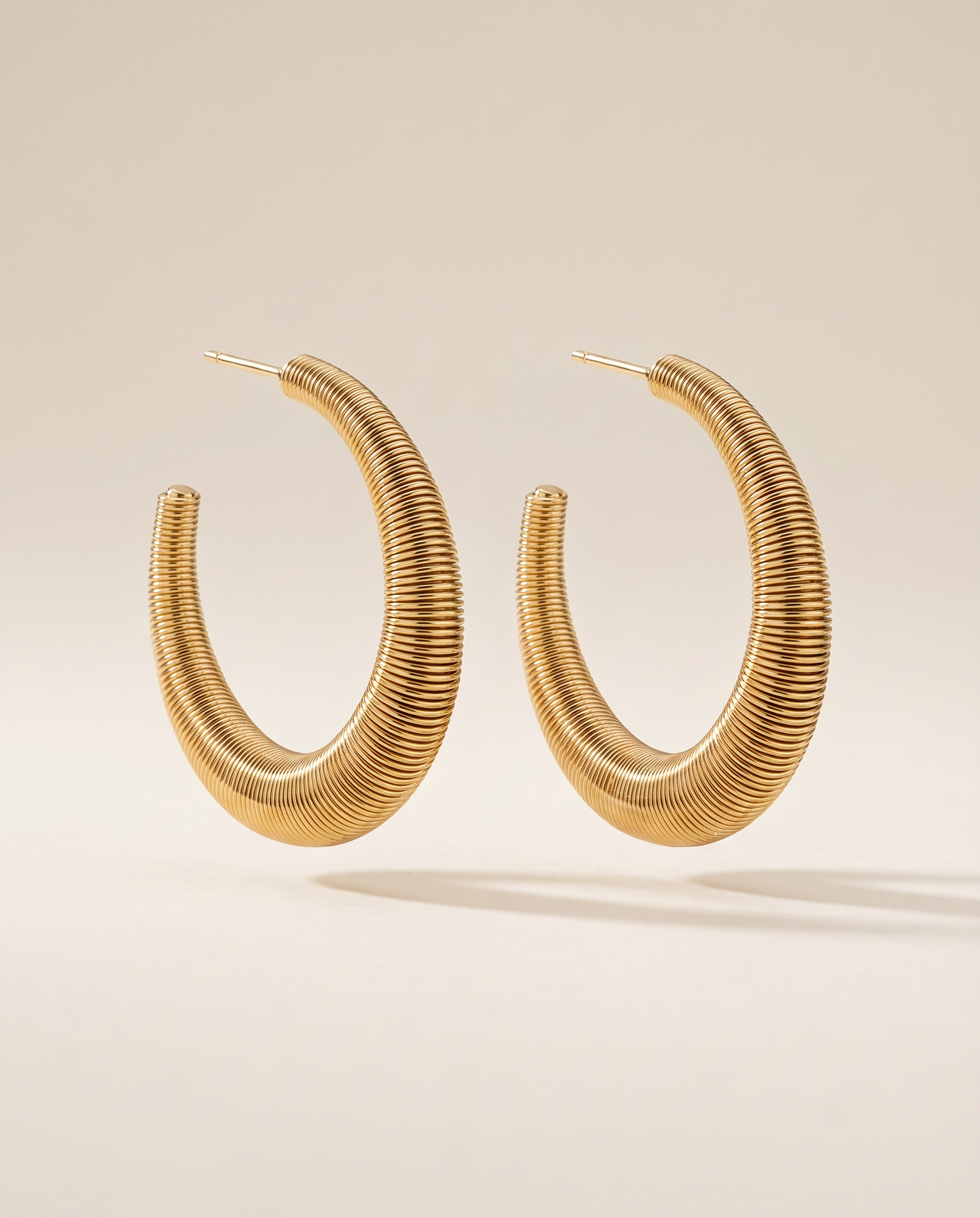 gouden oorbellen met ribbel structuur hoops close up
