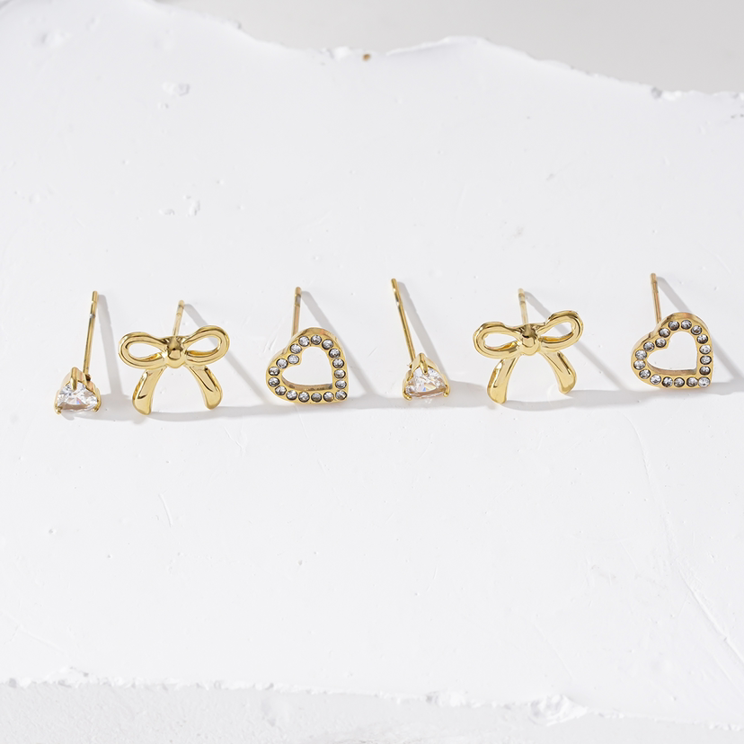 Detail van goudkleurige oorbellen met strikje uit set