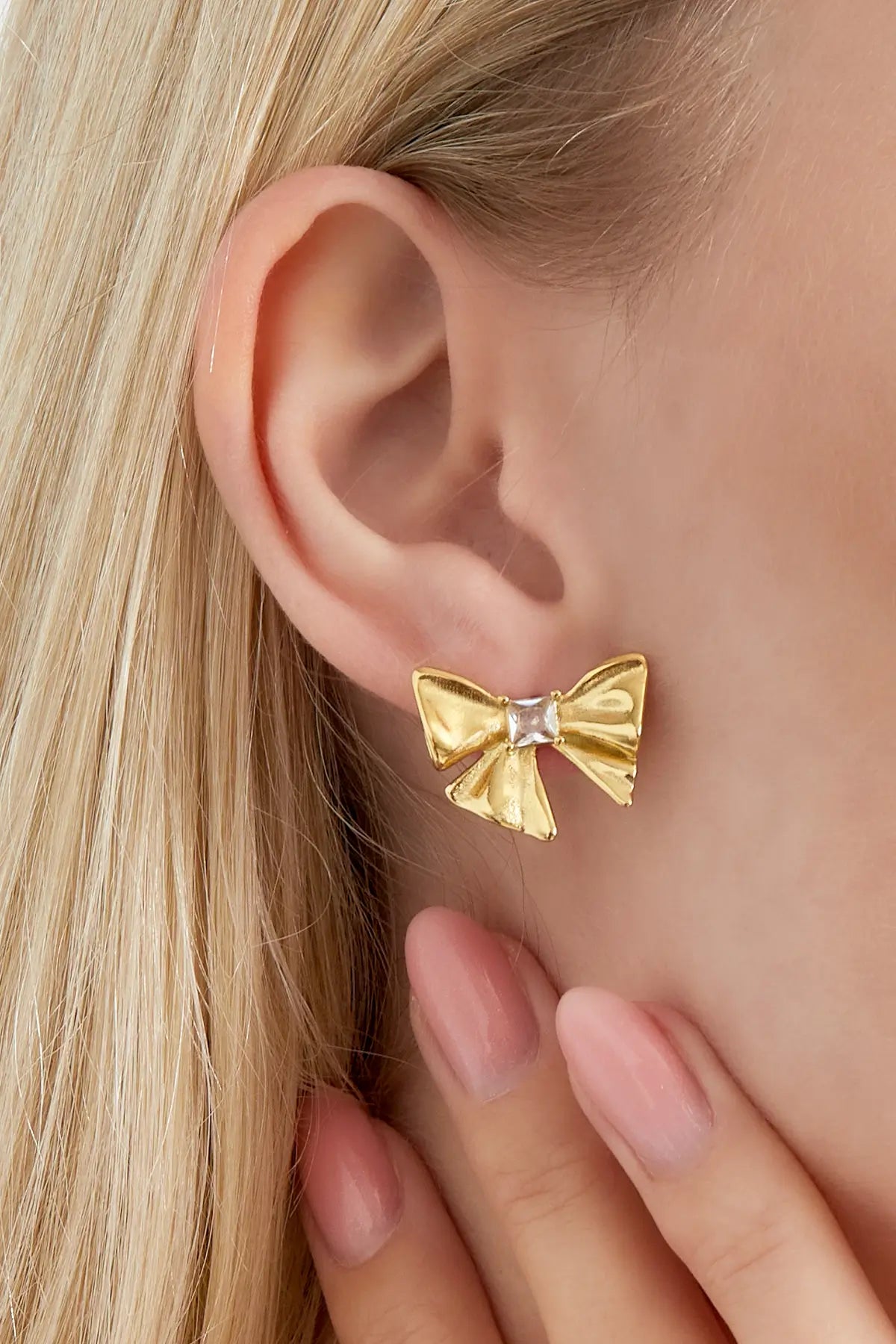 oorbellen strik era goud gedragen aan het oor close up